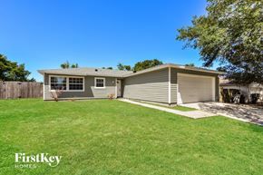 Apopka house for rent - a small gray house with a grassy yard and a fence