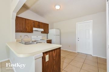 Apopka house for rent - a kitchen with an island and a sink and a refrigerator
