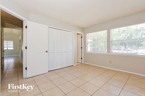 Apopka house for rent - a living room with a door to a hallway and a tiled floor