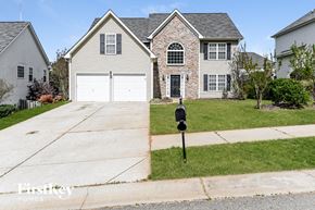 Mooresville house for rent - A house with a stone facade and a grey roof is for sale.