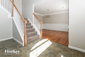 Mooresville house for rent - A staircase with a wooden handrail and a chandelier in a room with a wooden floor.