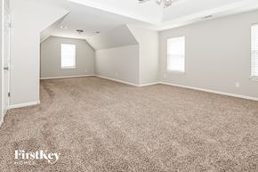 Mooresville house for rent - A spacious room with a carpeted floor and a ceiling fan.