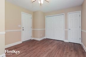 Dallas house for rent - the living room of a home with three doors and a wood floor