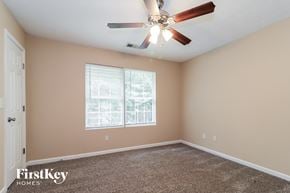 Dallas house for rent - a bedroom with a ceiling fan and a window