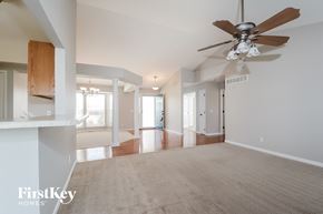 Wentzville house for rent - A spacious room with a ceiling fan and a carpeted floor.