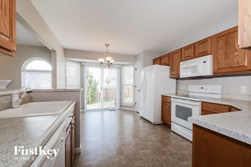 Wentzville house for rent - A kitchen with wooden cabinets and a white refrigerator.
