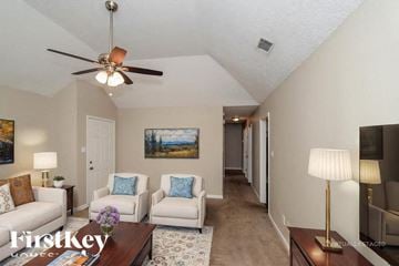 Helena house for rent - A well-lit living room with a white sofa, a coffee table, and a painting on the wall.