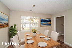Helena house for rent - A dining room with a wooden table set for six.
