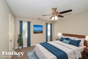 Helena house for rent - A bedroom with a large bed and a ceiling fan.