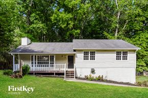 Woodstock house for rent - A white house with a porch and a tree in the background.
