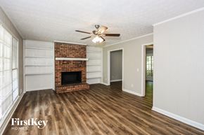Woodstock house for rent - A room with a fireplace and a ceiling fan.