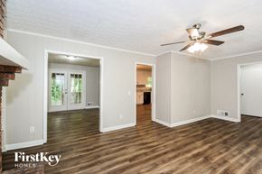 Woodstock house for rent - A spacious room with wooden floors and a ceiling fan.