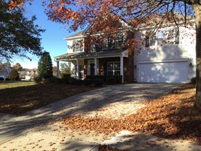 Mooresville house for rent - A house with a white garage door and a driveway covered in fallen leaves.