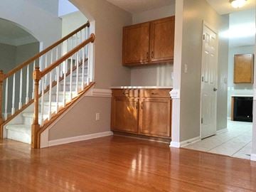 Mooresville house for rent - A kitchen with wooden cabinets and a staircase.