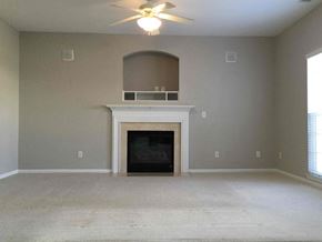 Mooresville house for rent - A living room with a fireplace and a ceiling fan.
