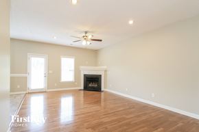 Clemmons house for rent - an empty living room with a fireplace and a ceiling fan