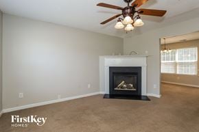 Stockbridge house for rent - A living room with a fireplace and a ceiling fan.