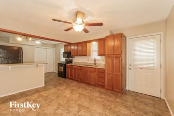 Blue Springs house for rent - a kitchen with wooden cabinets and a ceiling fan