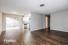 St. Petersburg house for rent - A spacious room with wooden floors and a sliding glass door leading to a balcony.