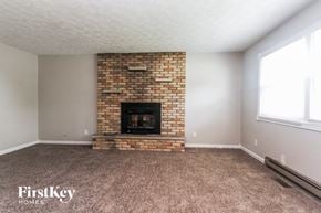 Monrovia house for rent - A room with a brick fireplace and carpeted floor.