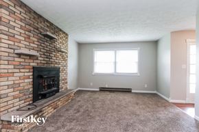 Monrovia house for rent - A room with a brick fireplace and a carpeted floor.