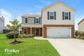 Calera house for rent - a white house with a white garage door in front of a green yard
