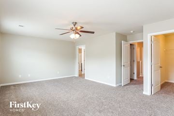 Calera house for rent - a living room with carpet and a ceiling fan