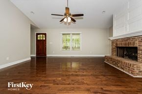 Fayetteville house for rent - a living room with a brick fireplace and a ceiling fan