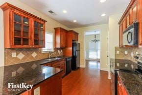 Mcdonough house for rent - a kitchen with black granite counter tops and wooden cabinets