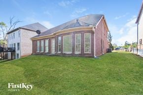 Mcdonough house for rent - the backyard of a brick house with a grass lawn and a gazebo