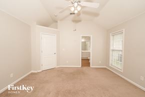 Calera house for rent - A spacious room with a ceiling fan and carpeted floor.