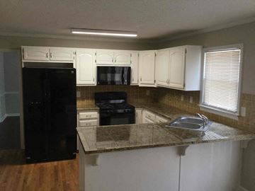Newnan house for rent - a kitchen with white cabinets and a counter top