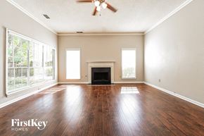 Loganville house for rent - an empty living room with wood floors and a fireplace