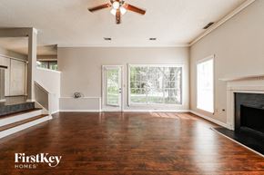 Loganville house for rent - an empty living room with a fireplace and a ceiling fan