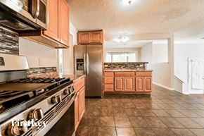 Loganville house for rent - a kitchen with stainless steel appliances and wooden cabinets
