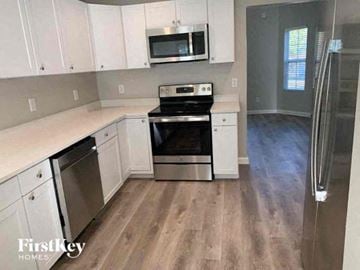 Covington house for rent - a kitchen with stainless steel appliances and white cabinets