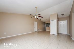 Kissimmee house for rent - A spacious room with a ceiling fan and beige walls.
