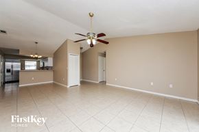 Kissimmee house for rent - A spacious room with a ceiling fan and beige walls.