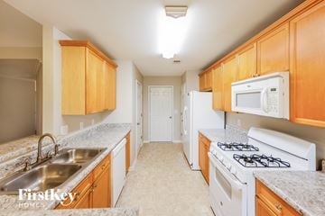 Helena house for rent - A kitchen with wooden cabinets and a white stove top oven.