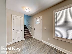 Concord house for rent - A hallway with a staircase and a window with blinds.