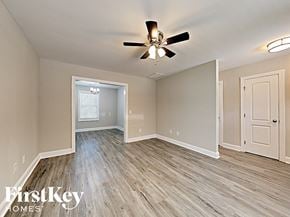 Concord house for rent - A room with a ceiling fan and light fixture, and a doorway leading to another room.