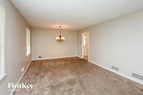 Lawrenceville house for rent - an empty living room with carpet and a chandelier