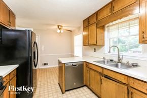 Lawrenceville house for rent - a kitchen with wooden cabinets and a sink and a refrigerator