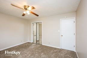 Lawrenceville house for rent - a bedroom with a ceiling fan and a mirrored closet