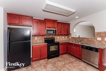 Odenville house for rent - A kitchen with red cabinets and black appliances.