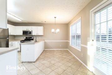 Lawrenceville house for rent - a kitchen with white cabinets and a large window