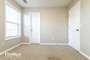 Lawrenceville house for rent - a bedroom with two doors and a window and a carpeted floor