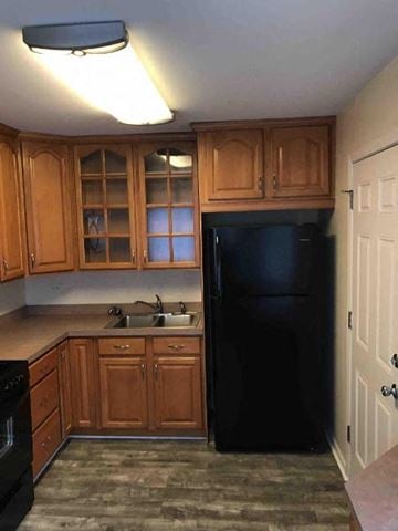 Glenwood house for rent - a kitchen with a black refrigerator and a sink