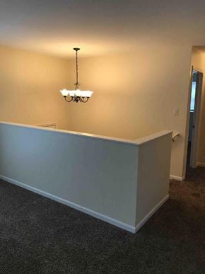 Glenwood house for rent - an empty room with a chandelier and a white wall