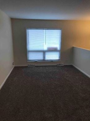 Glenwood house for rent - an empty room with a window and a carpet